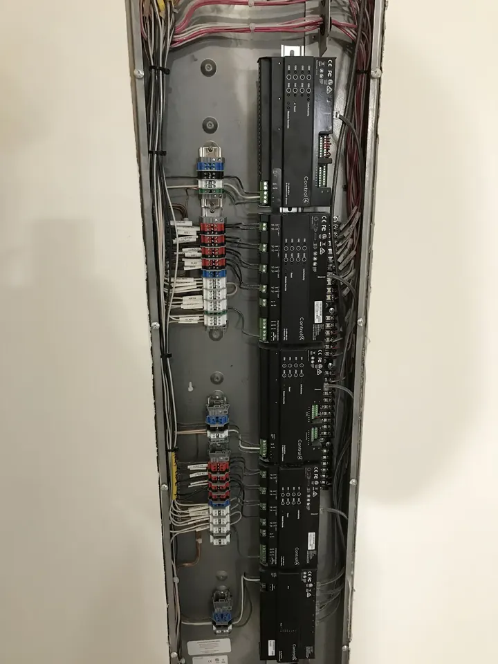 A Control4 lighting control panel and its wiring, set in a wall