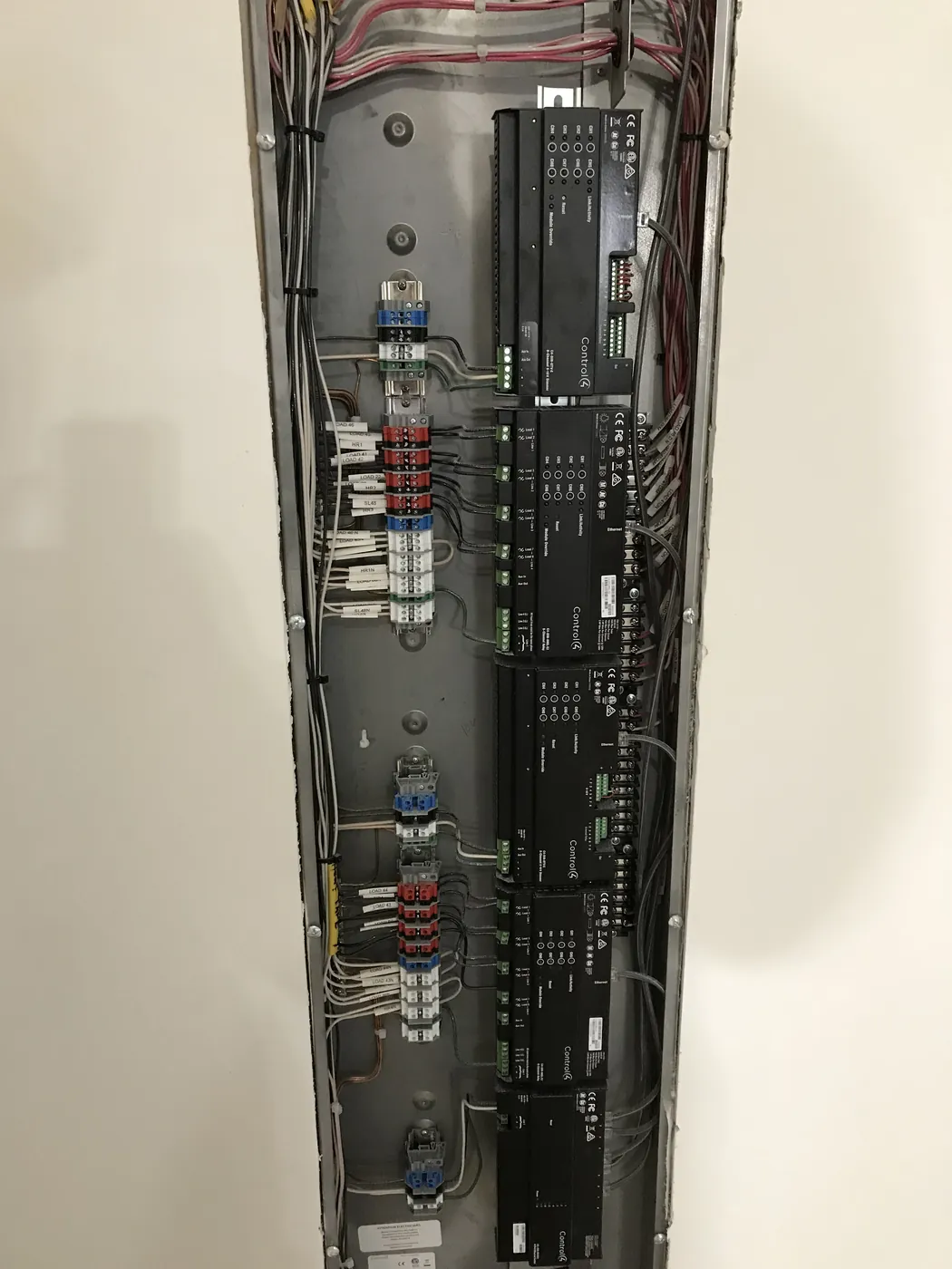 A Control4 lighting control panel and its wiring, set in a wall