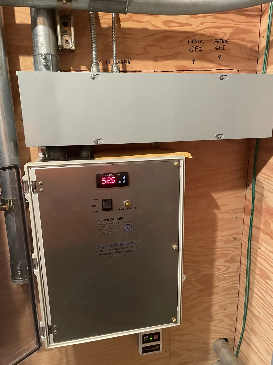 A heat tape control panel with a digital readout, mounted on plywood