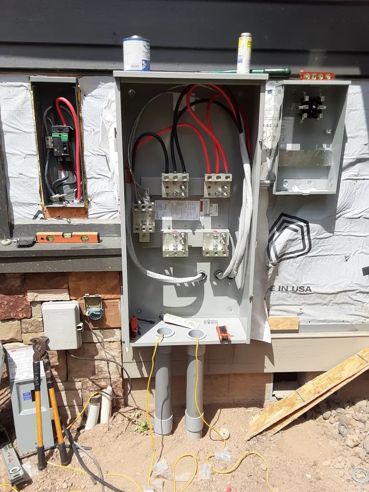 A new meter base and service panel on a house under construction