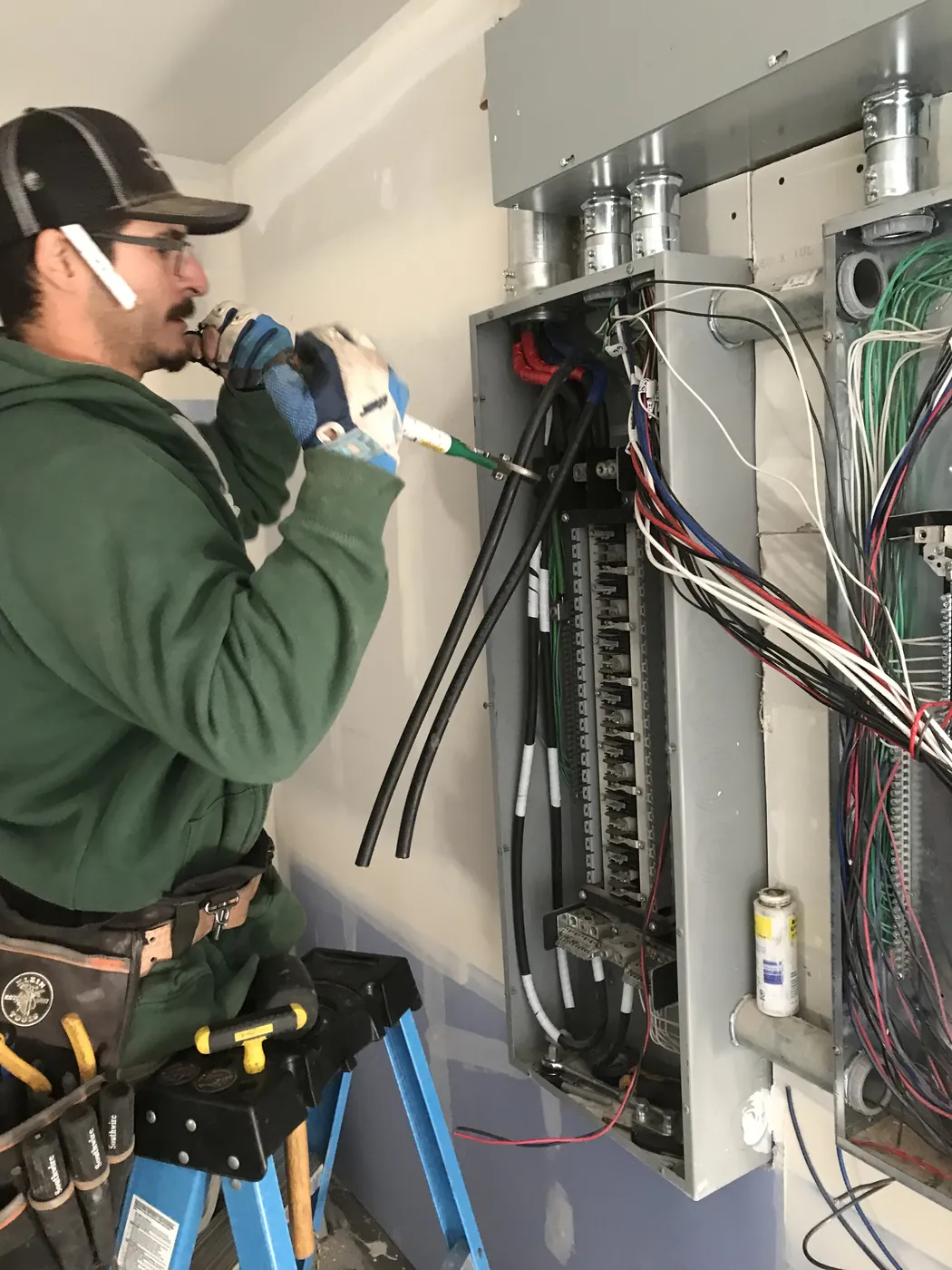An electrician wiring an open panel in a restaurant